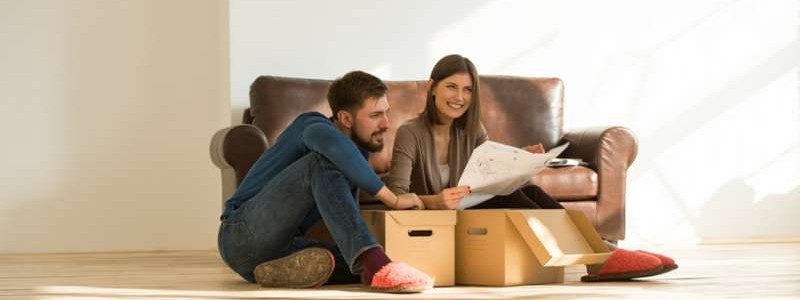 young couple sitting on the floor and planning for a house relocation