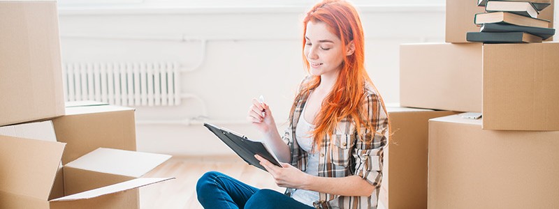 woman sitting on the floor and noting down something on a notepad