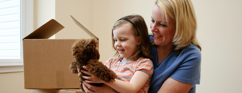 woman and her daughter playing with a teddy