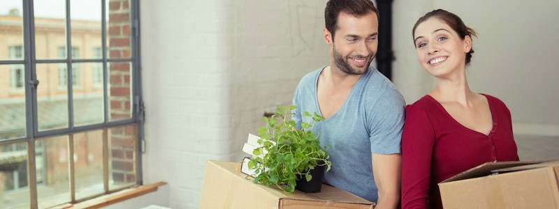 young couple holding cardboard boxes preparing to relocate