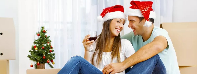 young couple wearing christmas hats celebrating their house relocation