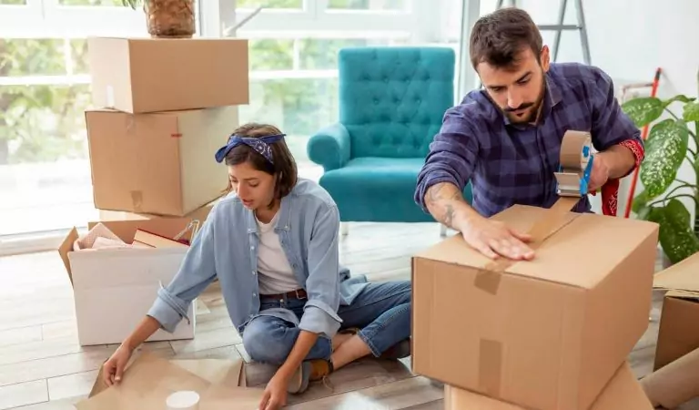 couple packing up cardboard boxes