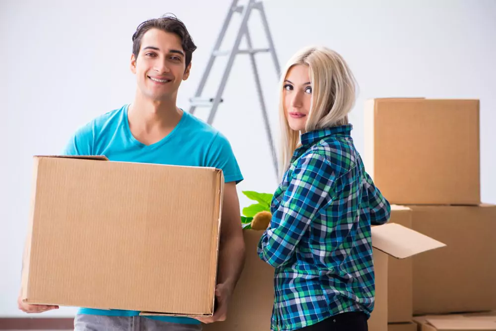 young man holding a cardboard box with a woman with brown hair