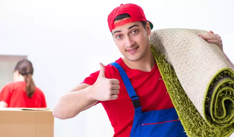 young man with a carpet showing thumbs up