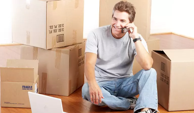 young man talking over a phone and sitting on the floor