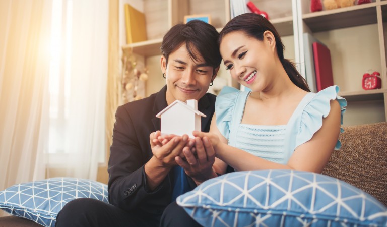 couple with a dummy house sitting inside of a house