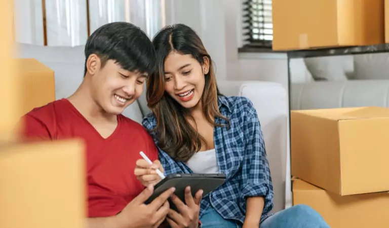 couple sitting on the floor and searching for something on a tablet