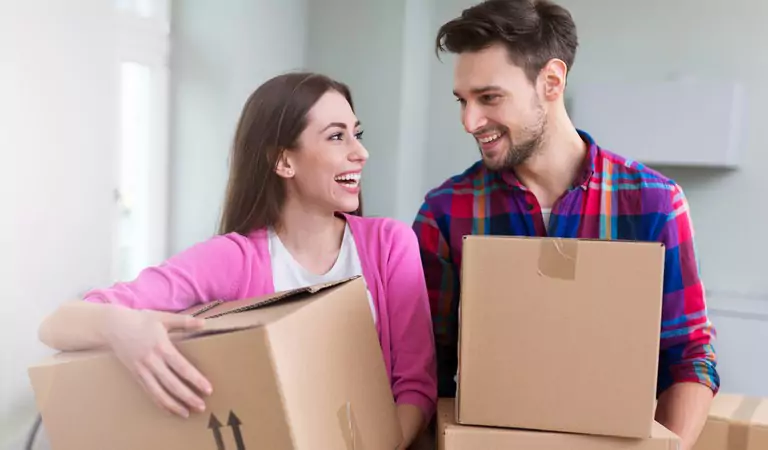 couple with cardboard boxes inside of their new house