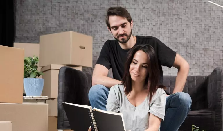 couple sitting inside of a house and reading a book