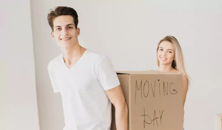 couple holding a heavy cardboard box
