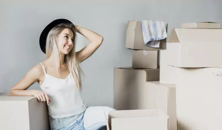 woman looking confusing while sitting with some cardboard boxes
