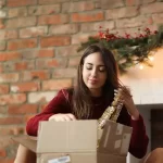 woman sitting on the floor and packing up a box