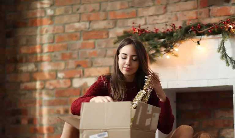 woman sitting on the floor and packing up a box