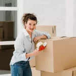 woman with some cardboard boxes inside of a house