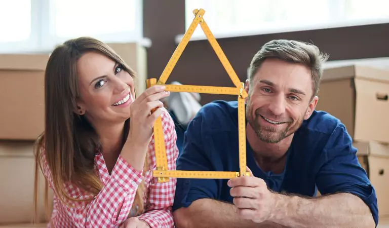 couple inside of a house with an inchtape of a house shape