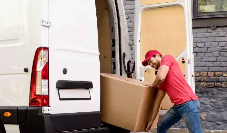 young man loading a box in a moving van